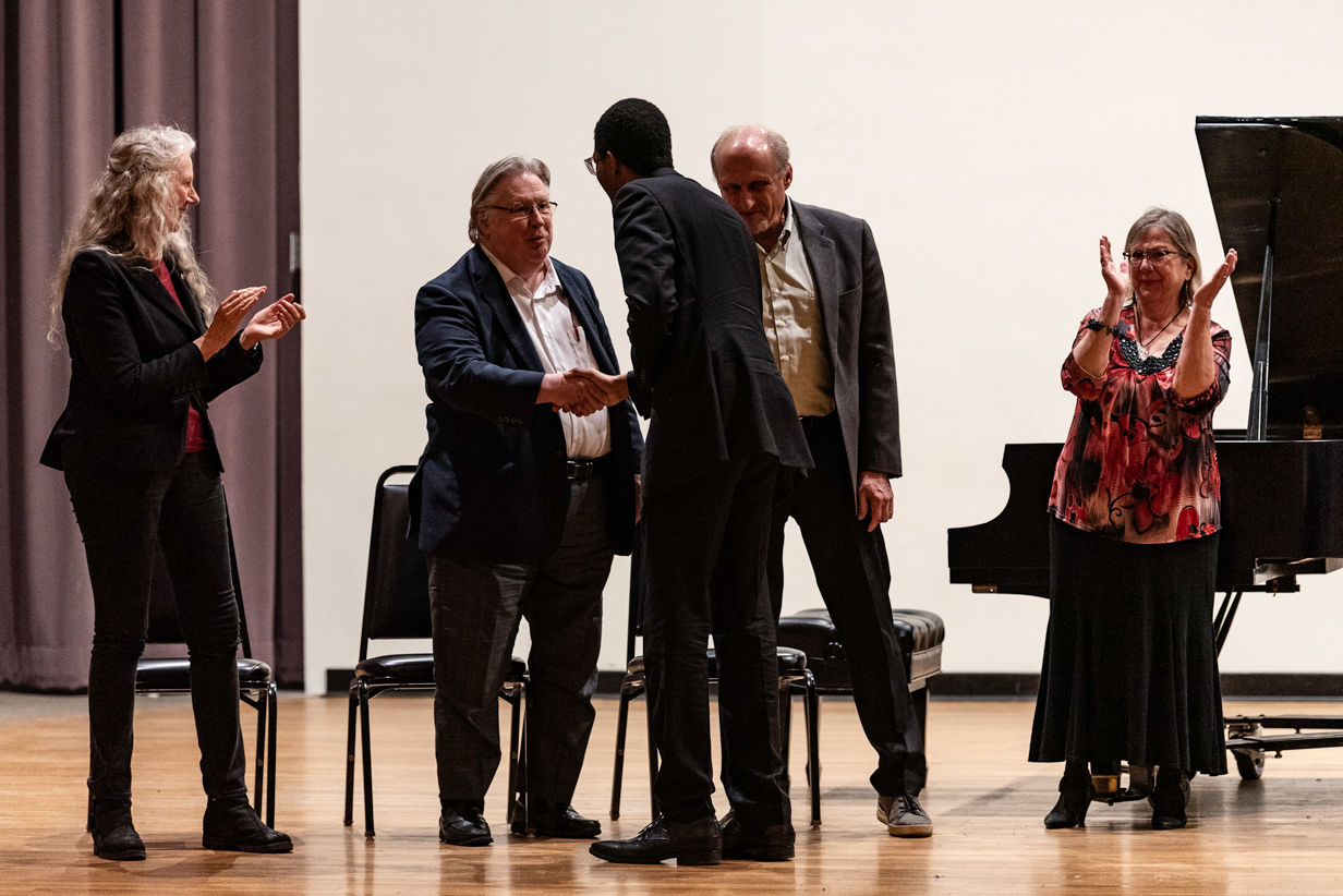 Competition guests greeting each other onstage
